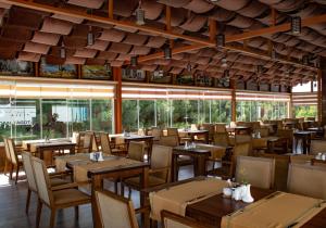 a restaurant with wooden tables and chairs and windows at Grand Hotel Europe in Baku