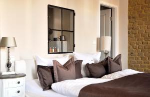 a bedroom with a bed with pillows and a mirror at Klosterhotel Neuzelle in Neuzelle