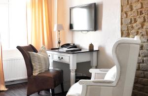 Zimmer mit einem Schreibtisch, einem Stuhl und einem Spiegel in der Unterkunft Klosterhotel Neuzelle in Neuzelle