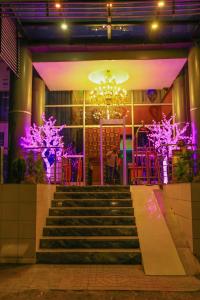 Denver boutique hotel في أديس أبابا: مجموعة من السلالم أمام مبنى ذو أضواء أرجوانية