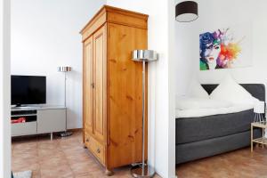 ベルリンにあるApartment SWINE in Mitte - Cozy Family & Business Flair welcomes you - Rockchair Apartmentsのベッドの横に木製キャビネットが備わるベッドルーム1室が備わります。