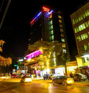 Una ciudad por la noche con coches estacionados frente a un edificio en Denver boutique hotel en Addis Abeba