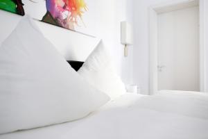ベルリンにあるApartment SWINE in Mitte - Cozy Family & Business Flair welcomes you - Rockchair Apartmentsの白いベッド(白い枕付)が備わるベッドルームです。