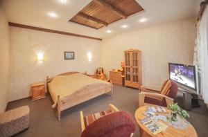 a bedroom with a bed and a tv and a table at Leo in Daugavpils