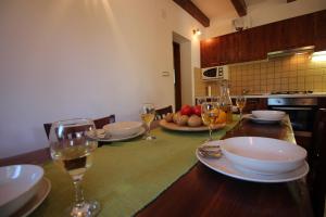a kitchen with a table with plates and glasses of wine at House Marko Breze in Ledenice