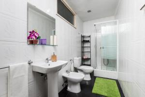a white bathroom with a sink and a toilet at Metro Casa Música Apartments and Rooms in Porto