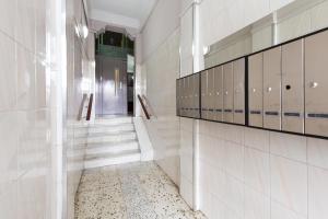 un couloir avec des murs en carrelage blanc et une porte dans l'établissement Key Sagrada Familia - Carrer Del Clot, à Barcelone