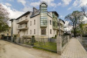 un gran edificio blanco con una valla delante en Apartment with Terrace and Sauna by Grand Apartments, en Sopot