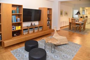 uma sala de estar com uma televisão de ecrã plano e mobiliário em Athens Destination: a home away from home em Atenas
