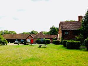 a picnic table in the grass in front of a house at Oldlands Farmhouse Gatwick in Horley