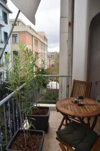 einen Balkon mit einem Tisch und zwei Pflanzen darauf in der Unterkunft Athens Destination: a home away from home in Athen