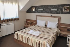 a bedroom with a bed with two towels on it at Apartman Vlada b14 in Kopaonik +8 photos