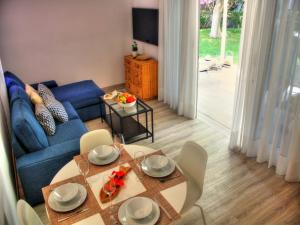 a living room with a blue couch and a table at Bungalows Los Melocotones in Maspalomas
