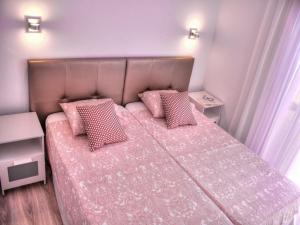 a bedroom with a pink bed with two pink pillows at Bungalows Los Melocotones in Maspalomas +84 photos