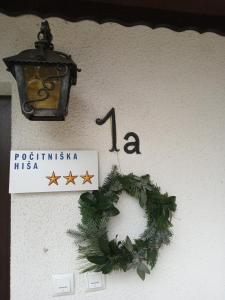ein Weihnachtskranz an einer Wand mit Licht und Schild in der Unterkunft Entire house Iris & Arnika in Bled