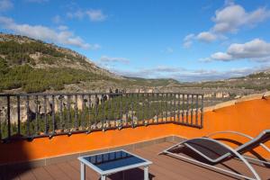 a balcony with chairs and a view of a mountain at Los Ojos de la Mora Apartamentos Boutique in Cuenca