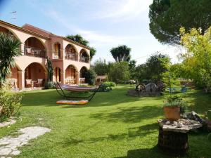 a house with a yard with a hammock in it at Marios Studios in Sidari