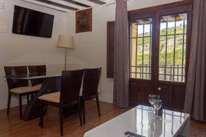 A television and/or entertainment centre at Los Ojos de la Mora Apartamentos Boutique
