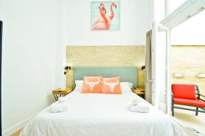 een slaapkamer met een bed en een rode stoel bij NineSuites in Sevilla