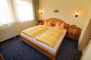 um quarto com uma cama grande com lençóis amarelos em Seehotel Zur Hopfenkönigin em Spalt