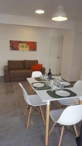 comedor con mesa y sillas blancas en Sargento cabral 73 en Mar del Plata