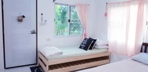 une chambre avec deux lits et une fenêtre dans l'établissement บ้านอิงธารา โฮมสเตย์ ศาลายา Baan ing tara homestay salaya, à Salaya