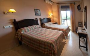 Łóżko lub łóżka w pokoju w obiekcie Hostal San Luis