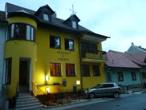 a yellow building with a car parked in front of it at Penzion U Urbanů in Němčice