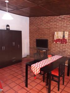 ein Wohnzimmer mit einem Tisch und einem TV in der Unterkunft Santa Rufina in San Isidro
