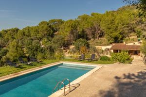 アルクーディアにあるEs Serval :) Relax and Sportsの椅子と家のあるプール