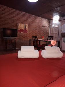ein Wohnzimmer mit 3 weißen Stühlen und einem roten Teppich in der Unterkunft Santa Rufina in San Isidro