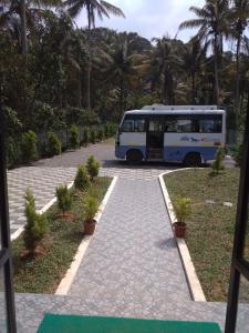 un autobús estacionado en una entrada con palmeras en Highrange Plaza, en Thekkady