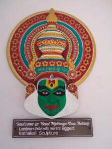 a sign on a wall with a picture of a mask at Highrange Plaza in Thekkady