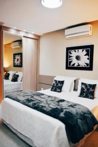 1 dormitorio con 1 cama grande en una habitación en Flat's Refúgio Vip, en Cabo Frío