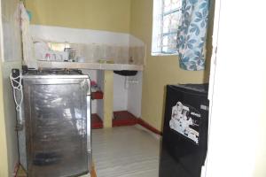 una pequeña cocina con fogones y nevera. en Private Guest Wing, en Mombasa