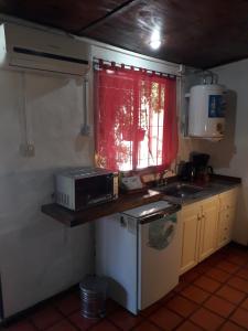 una pequeña cocina con microondas y fregadero en Santa Rufina en San Isidro