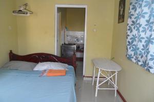 Un dormitorio con una cama y un taburete. en Private Guest Wing, en Mombasa