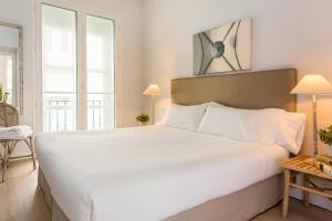 Łóżko lub łóżka w pokoju w obiekcie Suites Sevilla Plaza