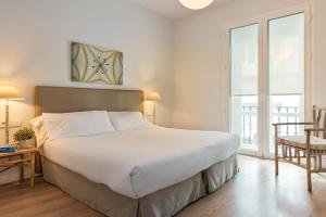 Łóżko lub łóżka w pokoju w obiekcie Suites Sevilla Plaza
