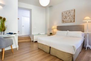 Łóżko lub łóżka w pokoju w obiekcie Suites Sevilla Plaza