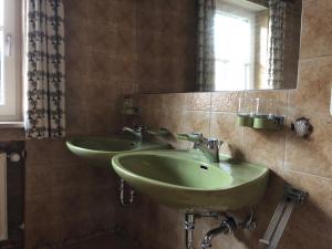 two green sinks in a bathroom with a mirror at Amelie Ferienwohnung in Garmisch-Partenkirchen