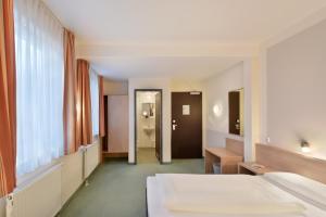 a hotel room with a bed and a corridor at meinHotel in Hamburg