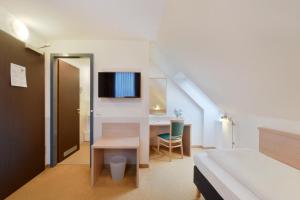 a bedroom with a bed and a desk with a computer at meinHotel in Hamburg