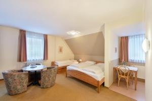 a room with a bed and a table and chairs at meinHotel in Hamburg