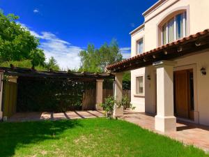 a house with a yard with a patio at La Guarida de Chacras in Ciudad Lujan de Cuyo