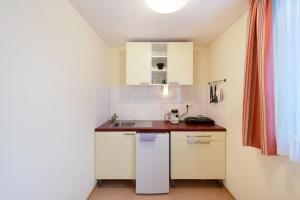 a small kitchen with white cabinets and a sink at meinHotel in Hamburg