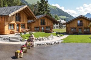 a large wooden house with a fountain in front of it at Ferienhütten Lechtal Chalets in Elbigenalp