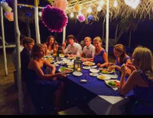 a group of people sitting around a table eating food at Jasmine Garden Beach Guest House in Hikkaduwa