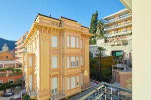 een geel gebouw aan de zijkant van een gebouw bij Castelfranco Appartamenti a 100 metri dal mare in Finale Ligure