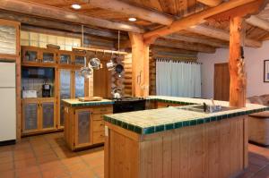 - une grande cuisine avec des murs en bois et des comptoirs en bois dans l'établissement Denton Cabin, à Taos Ski Valley